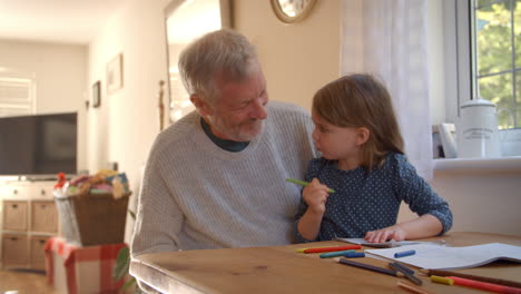 Grandfather-And-Granddaughter-Colouring-Picture-Together