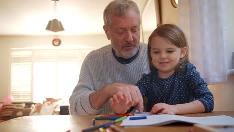 Grandfather-And-Granddaughter-Colouring-Picture-Together