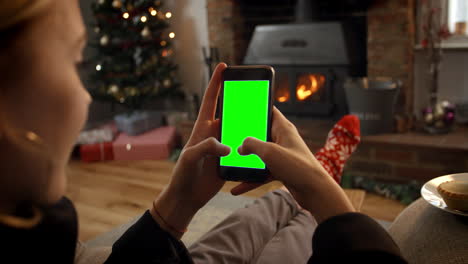 Woman-On-Line-With-Mobile-Phone-In-Room-Ready-For-Christmas