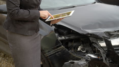 Loss-Adjuster-With-Digital-Tablet-Inspecting-Damaged-Car