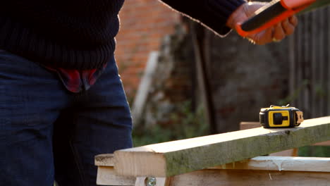 Close-Up-Of-Man-Measuring-And-Sawing-Wood-In-Slow-Motion