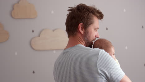 Father-Comforting-Baby-Son-In-Nursery
