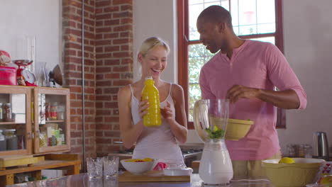 Mixed-race-couple-making-smoothies-together-at-home,-shot-on-R3D