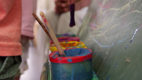 Close-Up-Of-Paint-Pots-On-Easel-During-School-Art-Lesson