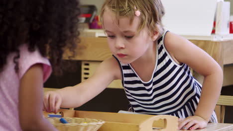 Schüler-An-Tischen-Zeichnen-Mit-Buntstiften-In-Der-Montessori-Schulklasse