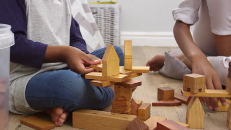 Mother-And-Son-Playing-With-Building-Blocks-In-Bedroom
