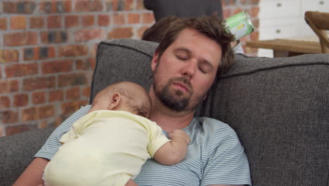 Tired-Father-With-Baby-Son-Sleeping-On-Sofa-Together