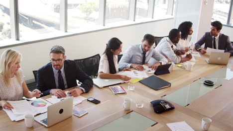 Group-Of-Businesspeople-Meeting-Around-Table-In-Boardroom