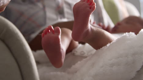 Close-Up-Of-Parents-Cuddling-Newborn-Baby-Son-In-Nursery
