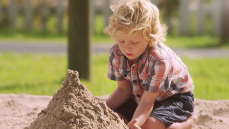Male-Pupil-At-Montessori-School-Playing-In-Sand-Pit-At-Breaktime