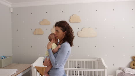 Mother-Comforting-Baby-Son-In-Nursery