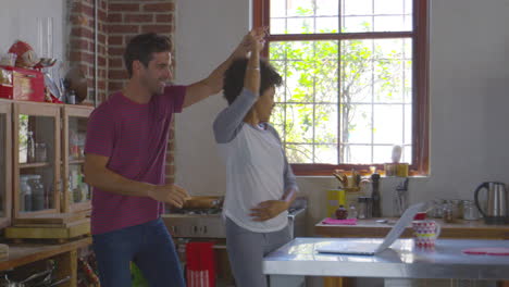 Young-mixed-race-couple-dancing-in-kitchen,-shot-on-R3D