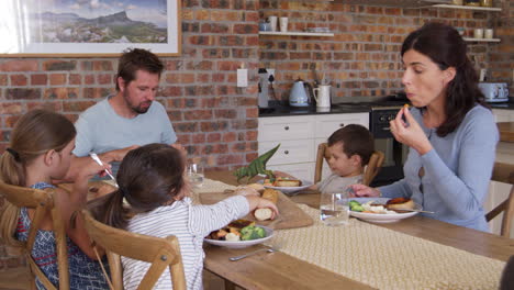 Family-Eating-Meal-In-Open-Plan-Kitchen-Together