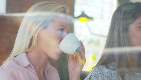 Three-Businesswomen-Meeting-In-Coffee-Shop-Shot-Through-Window