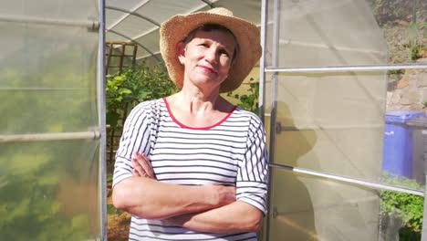 Portrait-Of-Mature-Female-Gardener-Outside-Allotment-Greenhouse