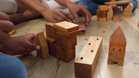 Mother-And-Children-Playing-With-Building-Blocks-In-Bedroom