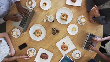 Overhead-Shot-Of-Businesspeople-Meeting-Around-Coffee-Shop-Table