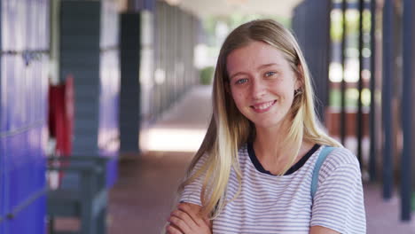 White-teenage-girl-walks-into-focus-in-high-school-corridor