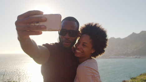 Young-Couple-Pose-For-Holiday-Selfie-On-Clifftop