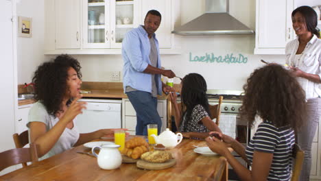 Family-With-Teenage-Children-Eating-Breakfast-In-Kitchen