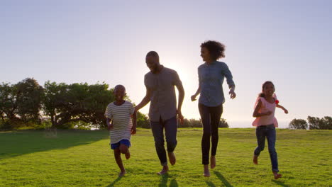 Joven-Familia-Negra-Corriendo-Hacia-Una-Cámara-En-Movimiento-En-Un-Parque
