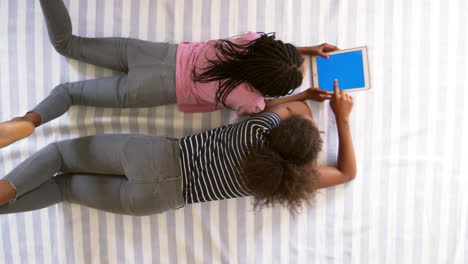 Draufsicht-Von-Mädchen-Im-Teenageralter,-Die-Ein-Digitales-Tablet-Auf-Dem-Bett-Betrachten
