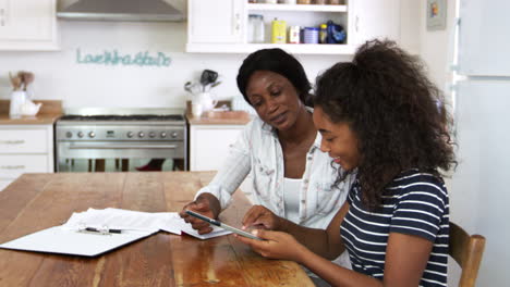 Mother-Helps-Teenage-Daughter-With-Homework-Using-Digital-Tablet