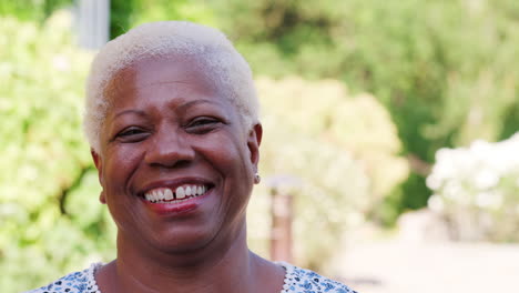 Senior-Mujer-Negra-Sonriendo-A-La-Cámara-Al-Aire-Libre,-Cerrar