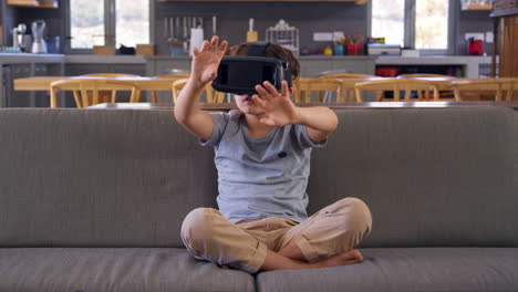 Boy-Sitting-On-Sofa-Wearing-Virtual-Reality-Headset