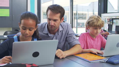 Lehrer-Hilft-Jungen-Schülern-Bei-Der-Verwendung-Von-Laptops-Im-Unterricht