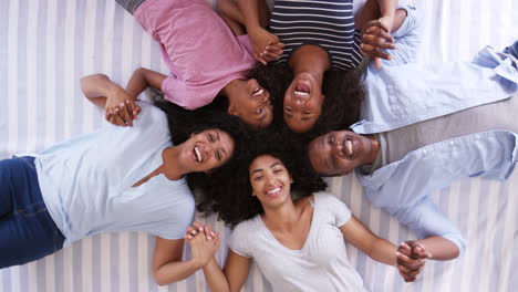 Overhead-View-Of-Family-With-Teenagers-Lying-On-Bed