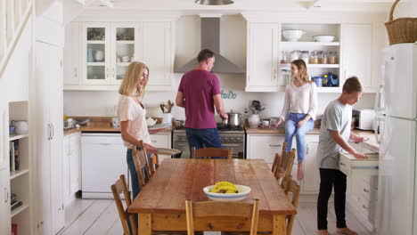 Family-With-Teenage-Children-Preparing-Breakfast-In-Kitchen