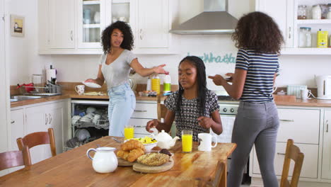 Daughters-Helping-Mother-To-Clear-Table-After-Family-Breakfast