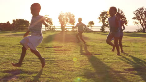 Grundschulkinder-Spielen-Mit-Einem-Fußball-Auf-Einem-Feld