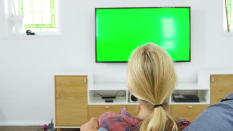 Rear-View-Of-Couple-Watching-Television-Together