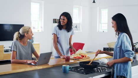 Three-Female-Friends-Preparing-Meal-Together-In-Modern-Kitchen