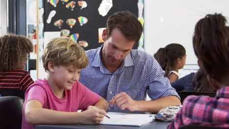 Lehrer-Und-Junger-Schüler,-Die-Notebook-In-Der-Klasse-Betrachten