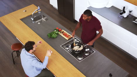 Overhead-View-Of-Men-Preparing-Meal-And-Talking-In-Kitchen