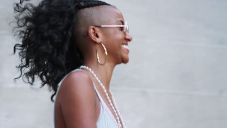 Fashionable-young-black-woman-wearing-sunglasses-walking-down-stairs-in-city-street,-close-up