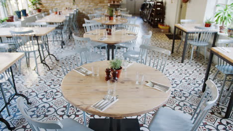 Leere-Gedecke-In-Einem-Restaurant-Mit-Runden-Tischen-Und-Blauen-Stühlen-Aus-Entenei,-Tagsüber,-Kippschuss