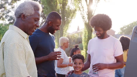 Familia-Hablando-En-Una-Barbacoa-Familiar-Negra-De-Varias-Generaciones