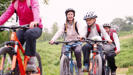 Eltern-Und-Kinder-Fahren-Mit-Dem-Mountainbike-Auf-Einem-Weg-In-Der-Natur-Während-Eines-Familiencampingurlaubs-Im-Lake-District,-Großbritannien