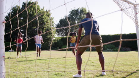 Two-black-adult-couples-playing-football-in-garden