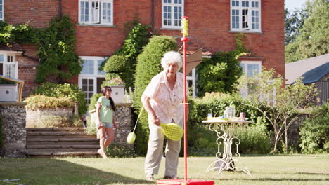 Active-Senior-Woman-Playing-Game-With-Bat-And-Ball-In-Garden