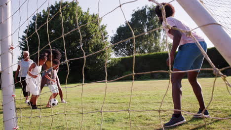 Schwarze-Familie-Mit-Mehreren-Generationen,-Die-Fußball-Im-Garten-Spielt