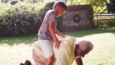 Senior-black-man-on-all-fours-with-grandson-riding-his-back