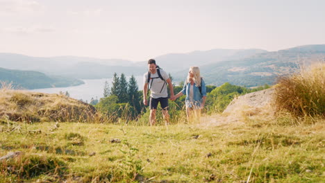 Slow-Motion-Shot-Of-Couple-Climbing-Hill-On-Hike-Through-Countryside-In-Lake-District-UK-Together