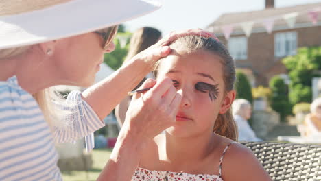 Slow-Motion-Shot-Of-Young-Girl-At-Face-Painting-Stall-At-Summer-Garden-Fete