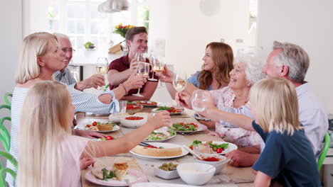 Zeitlupenaufnahme-Einer-Familie-Aus-Mehreren-Generationen,-Die-Am-Tisch-Sitzt-Und-Toast-Macht,-Bevor-Sie-Gemeinsam-Das-Essen-Genießt