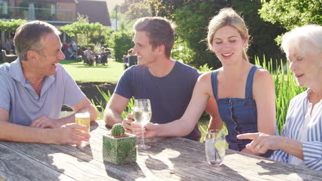 Parents-With-Adult-Offspring-Enjoying-Outdoor-Summer-Drink-At-Pub